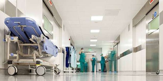 Blurred figures of people with medical uniforms in hospital corridor